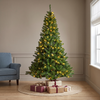 A pre-lit artificial Monarch Pine tree with warm white micro LED lights, placed in a room with holiday decorations.