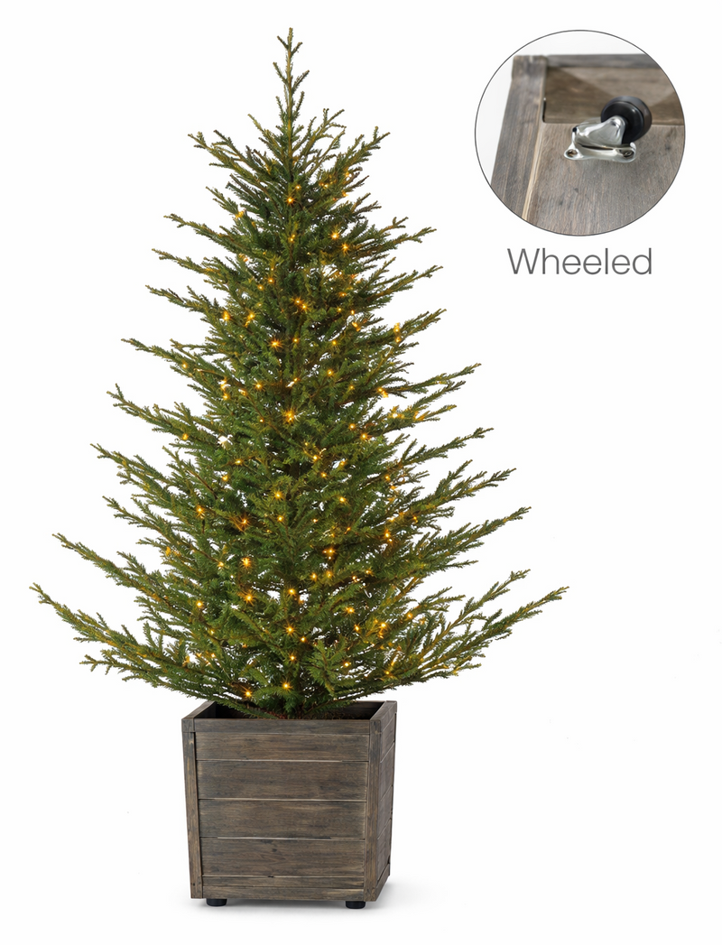 Decorative Christmas tree with lights in a wooden planter on a white background, featuring a 'Wheeled' label.