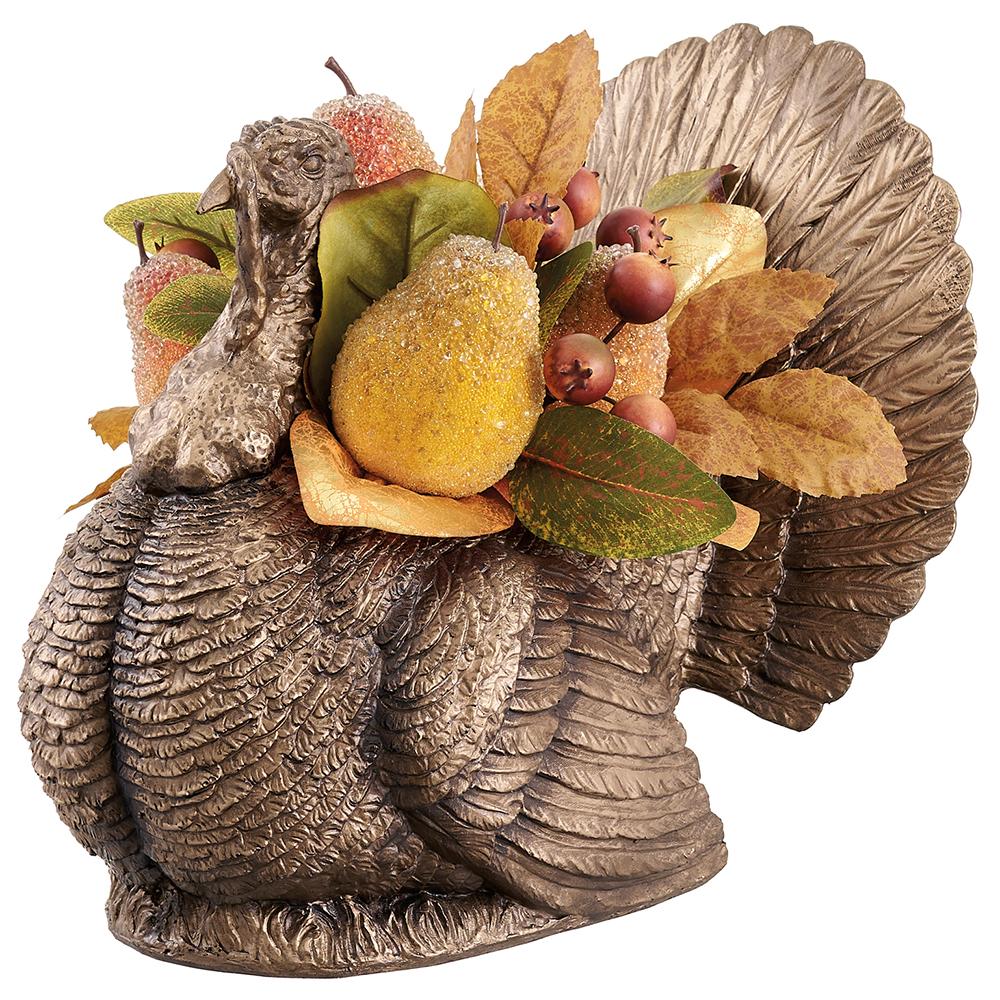 Decorative turkey figurine with autumn leaves and fruits on a white background