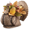 Decorative turkey figurine with autumn leaves and fruits on a white background