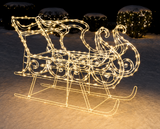 Decorative illuminated sleigh and reindeer figure on a snowy background