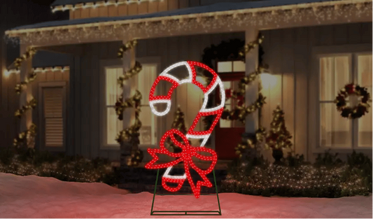 Decorative candy cane and bow light display in front of a house with Christmas lights and wreaths.