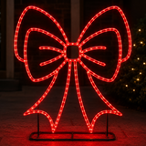 Red LED bow light decoration on a stand against a dark background