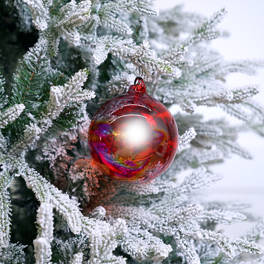 Red and gold Christmas ornament on a frosted tree branch
