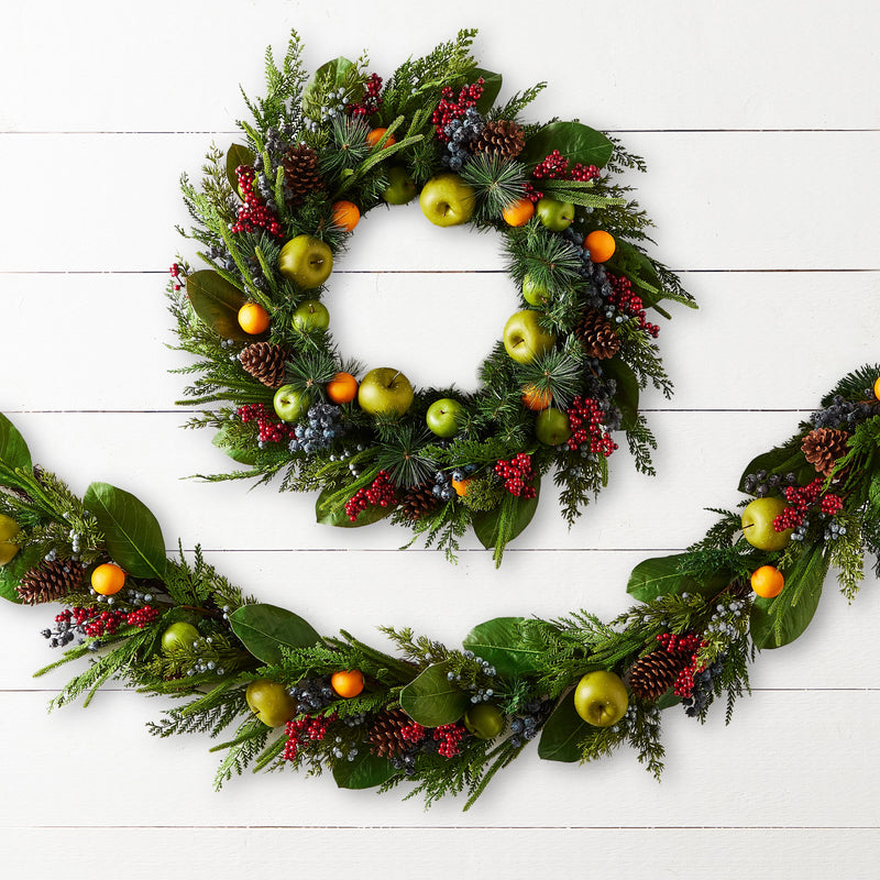 Decorative wreath with fruits and leaves on a white wooden background