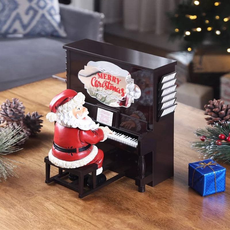 Decorative Christmas scene with a miniature piano and Santa Claus figure on a wooden surface.