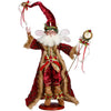 Decorative figure of a fairy-like character in a red and gold costume with a white beard, holding a staff and a bell.