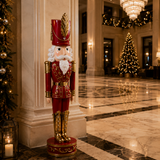 Decorative nutcracker figure in a grand hall with Christmas trees and lights.