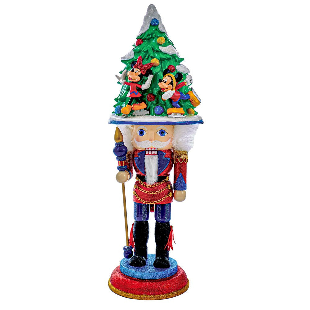 Decorative nutcracker with a Christmas tree on its head against a white background