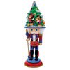 Decorative nutcracker with a Christmas tree on its head against a white background