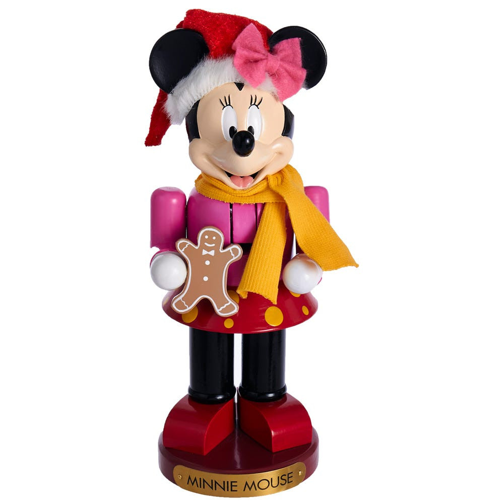 Minnie Mouse figurine in Christmas attire with a gingerbread man cookie on a white background
