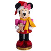 Minnie Mouse figurine in Christmas attire with a gingerbread man cookie on a white background