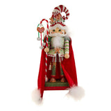 Decorative Christmas elf figurine with a candy cane hat and red cape on a white background