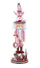 Decorative nutcracker figure in pink and white with a teapot on top, standing on a white background.