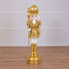 Decorative nutcracker figure with gold and white attire on a white background
