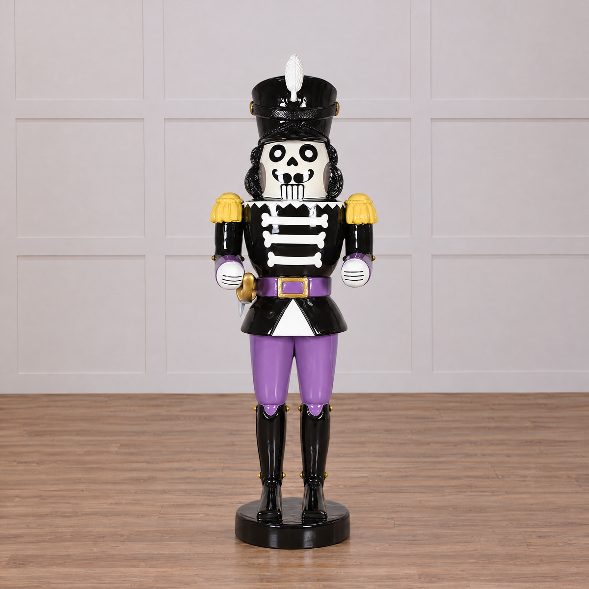 Skeleton nutcracker figurine with purple pants on a white background