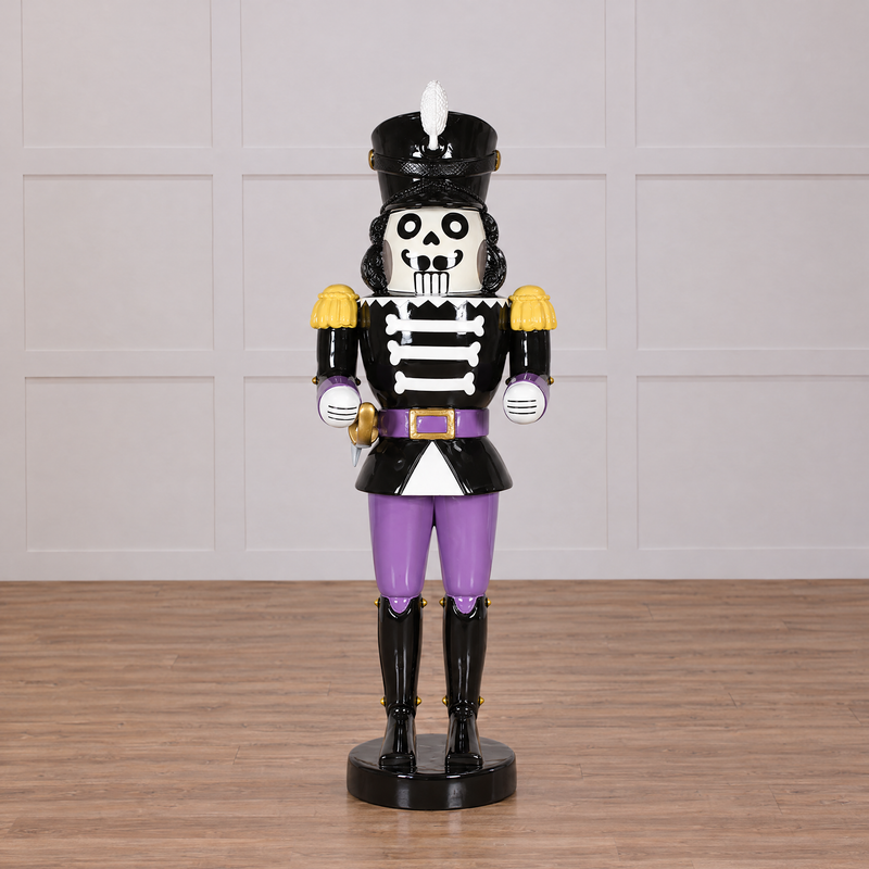 Skeleton nutcracker figurine with purple pants on a white background