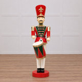 Decorative figure of a toy soldier with a drum on a beige background